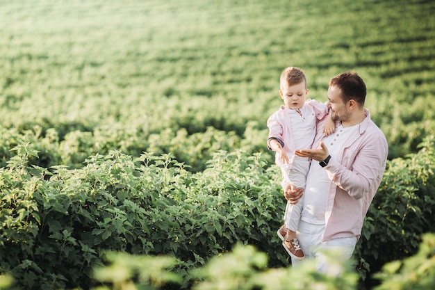 Kleine jongen met zijn vader op een groen veld