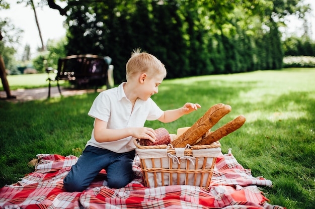 Kleine jongen neemt zijn handen het eten in de tuin