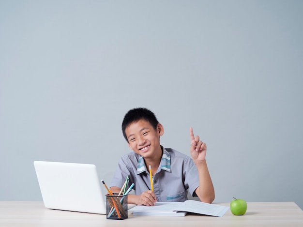 Kleine jongen online studeren met laptop. Afstandsonderwijs tijdens COVID-19 pandemie