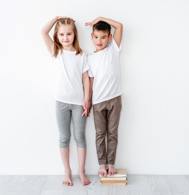 Kleine jongen permanent op boeken in de buurt van zus