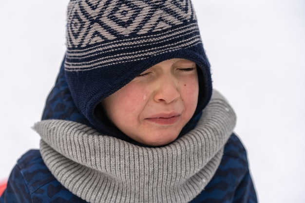 Kleine jongen schreeuwt en huilt. Emoties. Jongen in de winterkleren