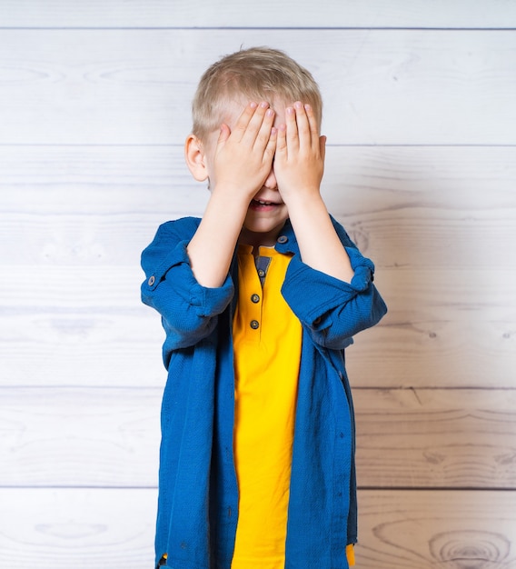 Foto kleine jongen sloot ogen met handen