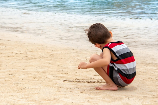 Kleine jongen speelt in het zand op het strand Kind speelt op het strand