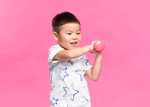 Kleine jongen speelt met dumbbell.