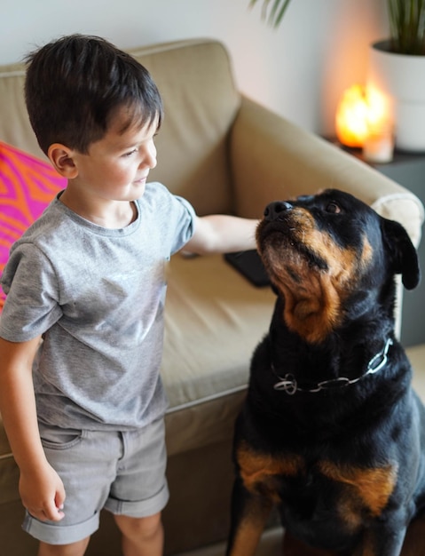 Kleine jongen speelt met een rottweiler-hond