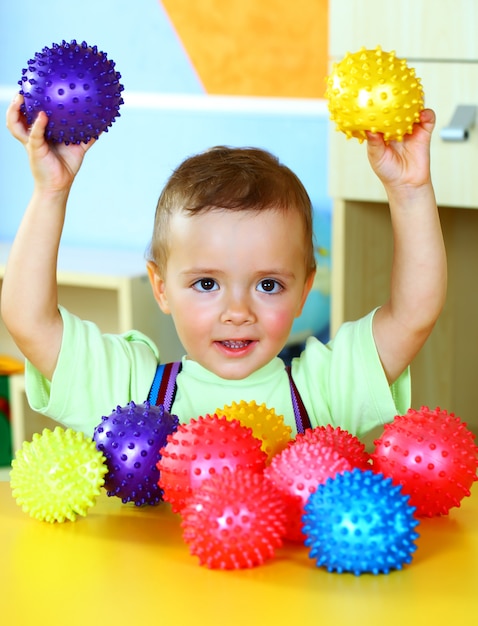 Kleine jongen speelt met gekleurde ballen