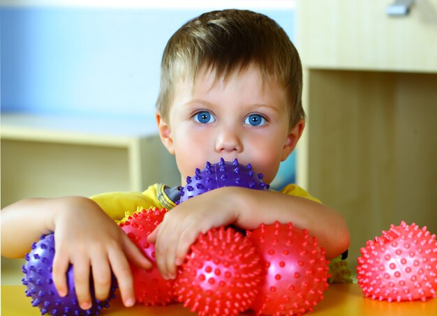 Kleine jongen speelt met gekleurde ballen