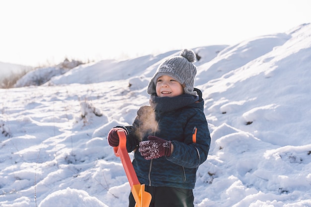 Kleine jongen speelt met sneeuw