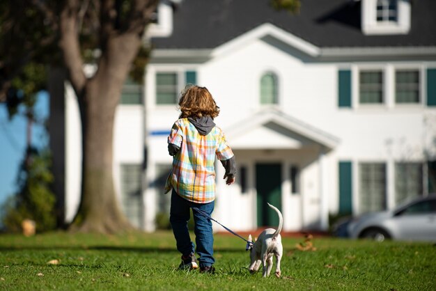 Kleine jongen spelen met puppy gelukkig kind wandelende hond