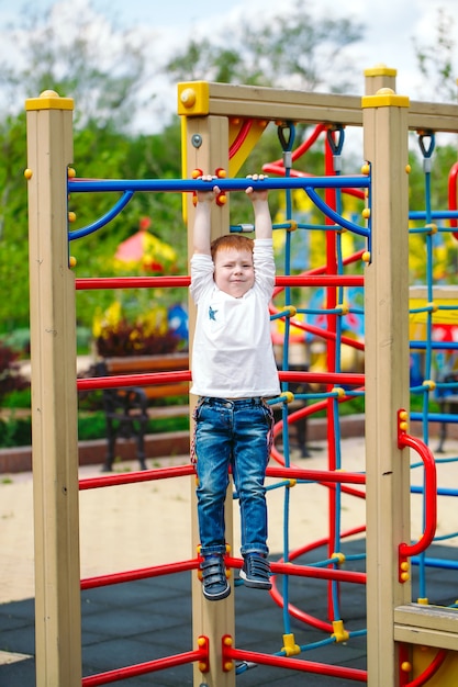 Kleine jongen spelen op de speelplaats.