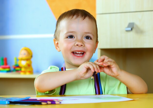 Kleine jongen tekent met kleurpotloden