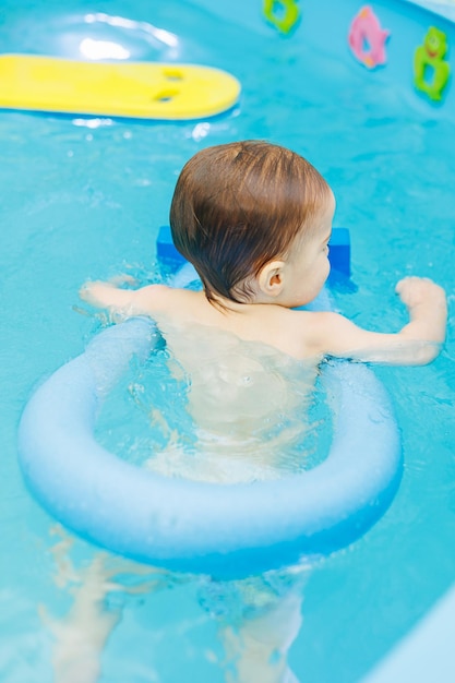 Kleine jongen van 2 jaar oud zijn in het zwembad Zwemlessen voor jonge kinderen