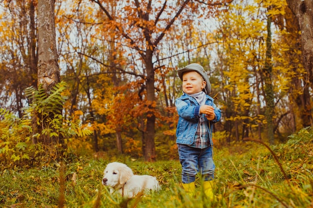 kleine jongen wandelen met golden retriever pup in het park