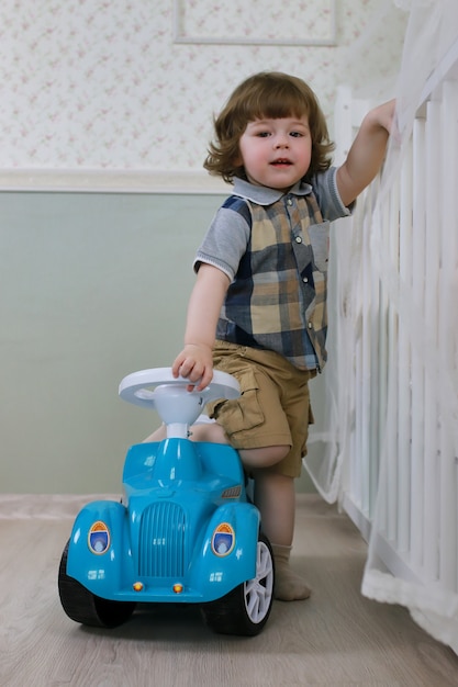 Kleine jongen zit op een speelgoedauto