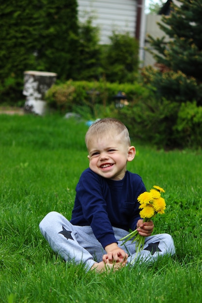 Kleine jongen zit op het gras. Selectieve focus