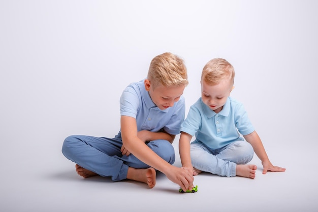 Kleine jongens spelen met auto's op een witte achtergrond