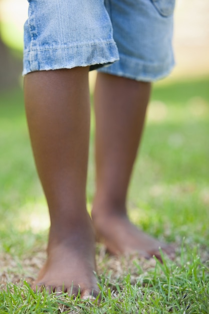 Kleine jongensbenen die zich op gras bevinden