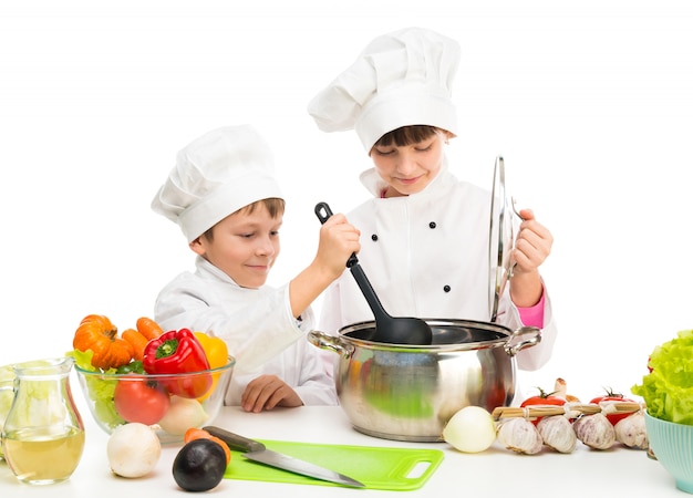 Kleine kinderen aan een tafel met groenten