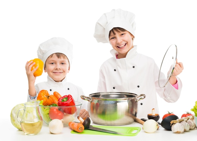 Kleine kinderen aan een tafel met groenten