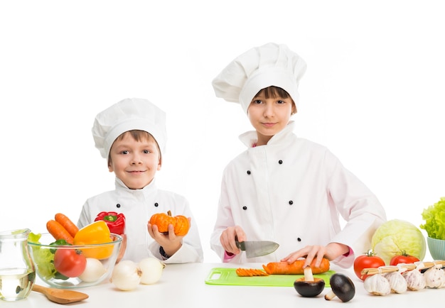 Kleine kinderen aan een tafel met groenten