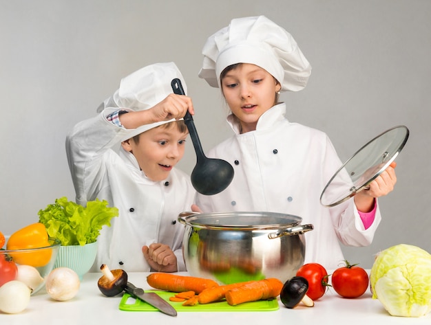 Kleine kinderen aan een tafel met groenten