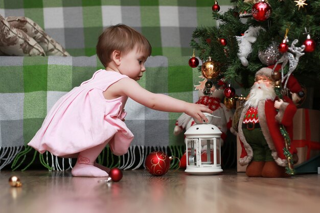 Kleine kinderen bij een kerstboom voor de vakantie