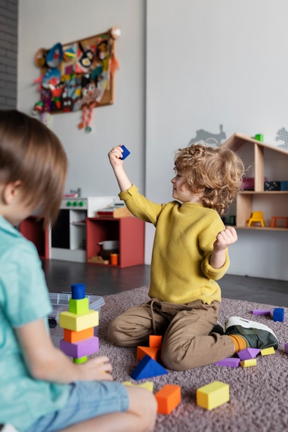 Kleine kinderen die samen spelen op de kleuterschool