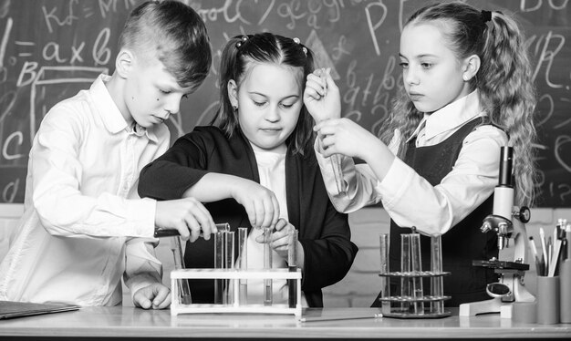 Foto kleine kinderen die scheikunde leren in schoollabstudenten die biologie-experimenten doen met microscoop kinderdag scheikunde terug naar school kleine kinderen op schoolles zelfverzekerde apotheker