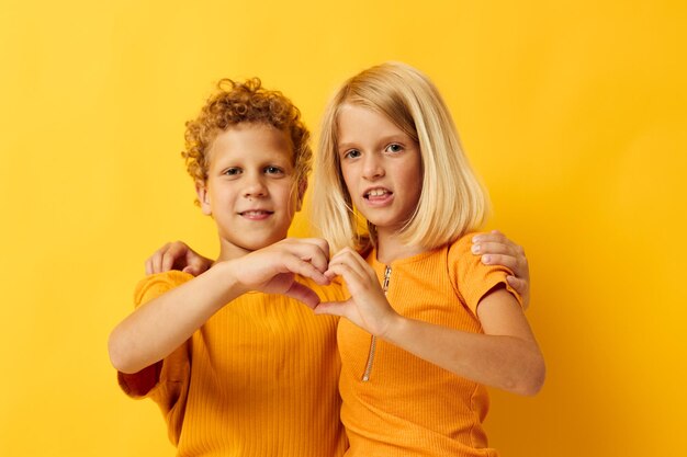 Kleine kinderen in gele t-shirts staan naast elkaar jeugdemoties gele achtergrond