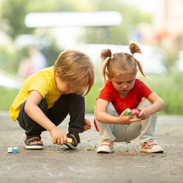 Kleine kinderen in park tekenen met krijt