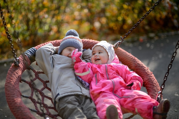 Kleine kinderen jongen en meisje rijden op een schommel