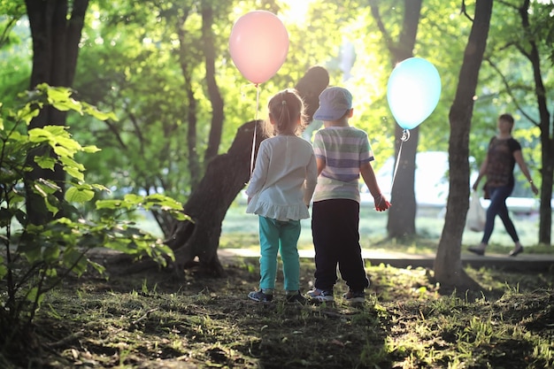 Kleine kinderen lopen in een park met ballonnen