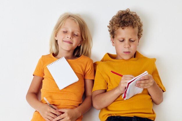 Kleine kinderen tekenen leuke spelletjes met notitieblok geïsoleerde achtergrond ongewijzigd