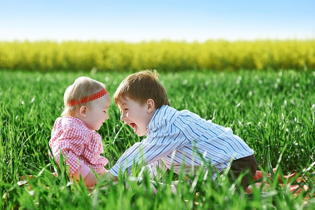 Kleine kinderenjongen en meisje spelen op groen gras