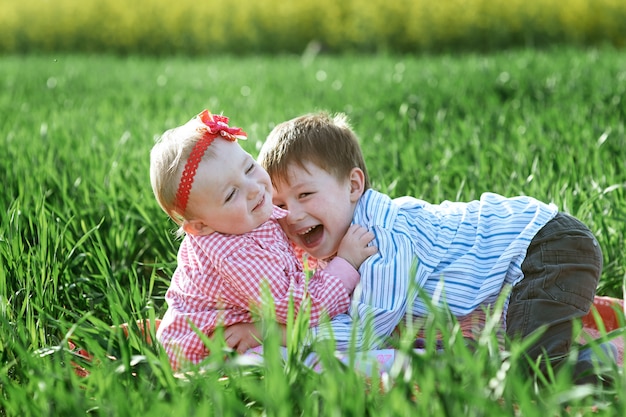 Kleine kinderenjongen en meisje spelen op groen gras