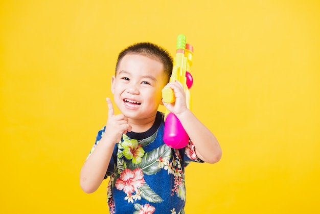 Kleine kinderenjongen zo gelukkig in Songkran-festivaldag die waterkanon houden