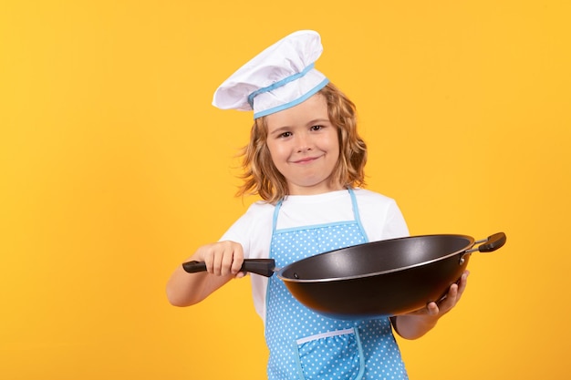 Kleine kok met kookpan Chef jongen jongen maken van gezonde voeding Portret van een klein kind in chef-kok hoed geïsoleerd op studio achtergrond Kind chef Koken proces