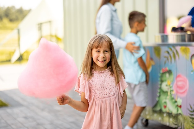 Foto kleine meisje met roze suikerriet.