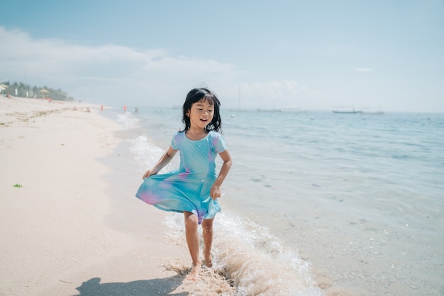 Kleine meisjes rennen en lachen op het strand