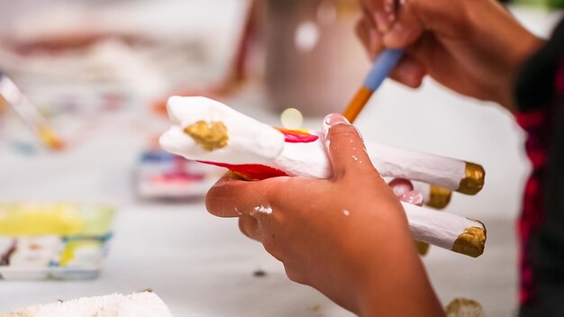 Kleine meisjes schilderen eenhoorn van papier-maché met acrylverf.