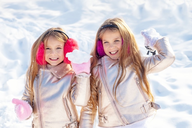 Kleine meisjes spelen met sneeuwballen