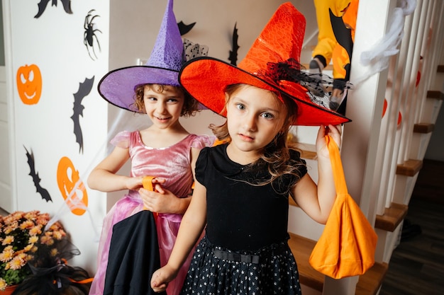 Kleine meisjesheksen wachten op Halloween-traktaties