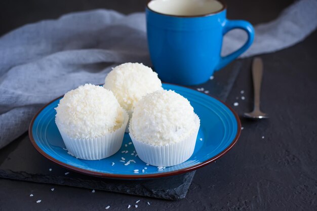 Kleine meringuecakes Pavlova met glazuur en kokosnoot Op een blauw bord Selectieve focus