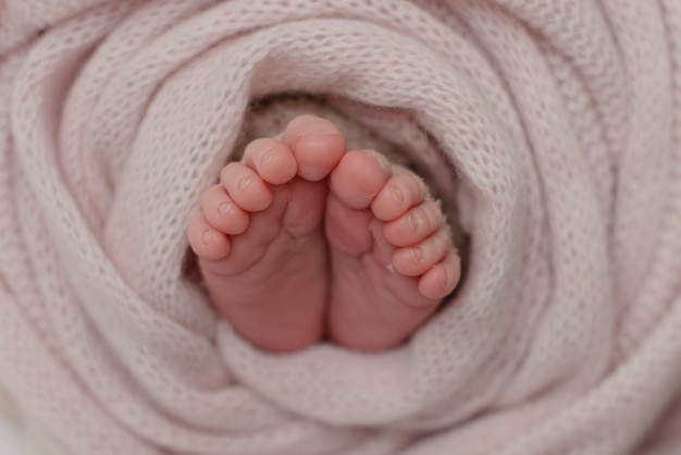 Kleine mooie beentjes van een pasgeboren baby in de eerste levensdagen Babyvoetjes van een pasgeboren baby