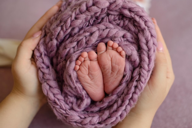 Kleine mooie beentjes van een pasgeboren baby in de eerste levensdagen Babyvoetjes van een pasgeboren baby