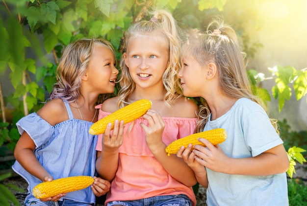 Kleine mooie meisjes fluisteren geheimen op buiten zomer achtergrond. vriendschap concept