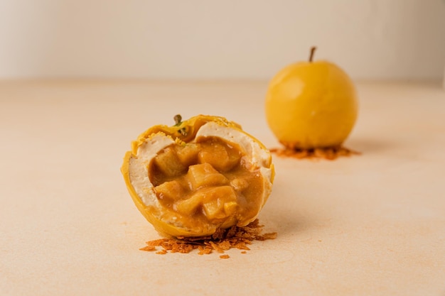 Kleine moussecakes in de vorm van een appel in tweeën gesneden om de fruitvulling voor Halloween te laten zien