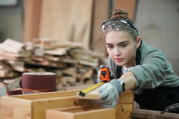 Kleine onderneming van een jonge vrouw Aantrekkelijke jonge vrouw timmerman ontwerper werkt in werkplaats