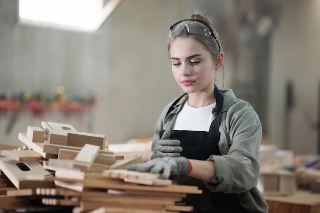 Foto kleine onderneming van een jonge vrouw mooie jonge vrouwelijke werknemer in een meubelwerkkamer die hout meet