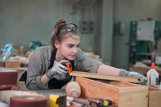 Foto kleine onderneming van een jonge vrouw op de achtergrond van een meubelatelier